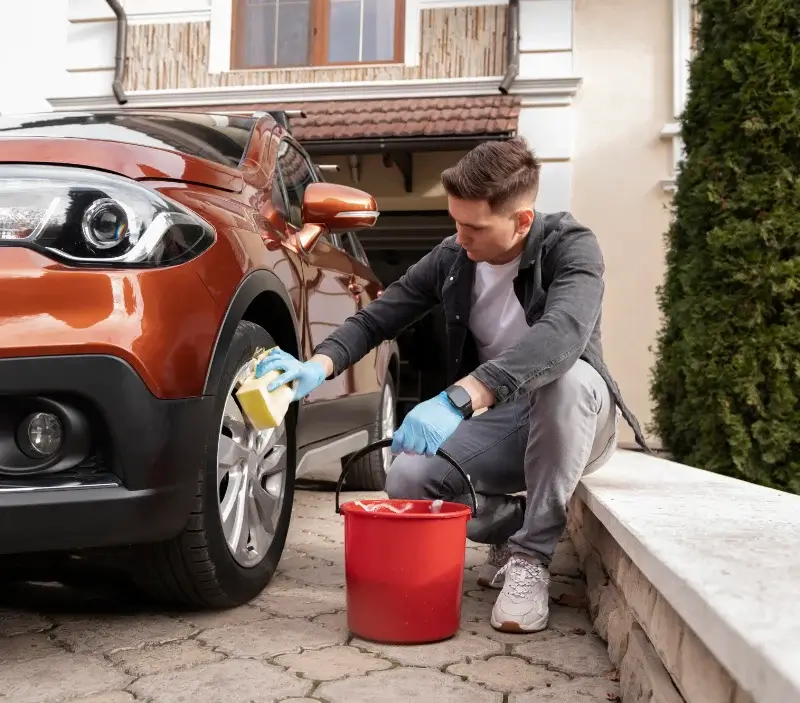 Lavage auto à domicile Auberives-sur-Varèze : professionnel intervenant sur un véhicule